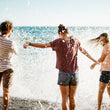 Load image into Gallery viewer, Friends play in ocean water on Hike & Seek day tour from Melbourne
