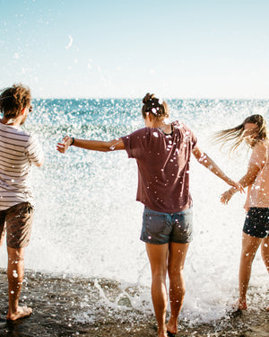 Friends play in ocean water on Hike & Seek day tour from Melbourne